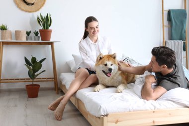 Çift ve Akita Inu köpek yatak odasında houseplants ile dekore