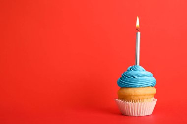 Kırmızı arka plan üzerinde mum ile Doğum günü cupcake, metin için alan