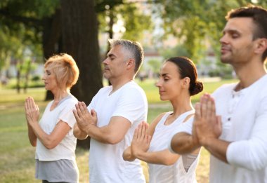 İnsanlar sabah parkta yoga yapıyor.