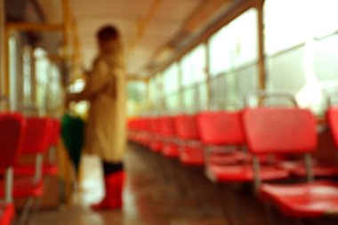 Yağmurlu günde tramvayda şemsiyeli kadının bulanık görünümü