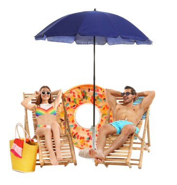 Beyaz arka plan karşı şezlong plaj aksesuarları ile genç çift