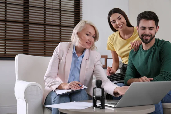 Vrouwelijke notaris werken met jong stel in Office — Stockfoto