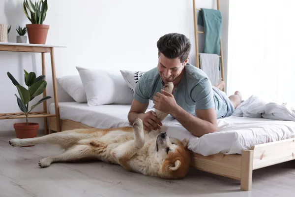 Muž a Akita inu v ložnici vyzdobené bymi — Stock fotografie