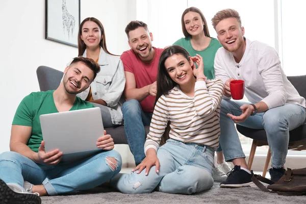 Group of happy people with laptop in living room — Stock Photo, Image