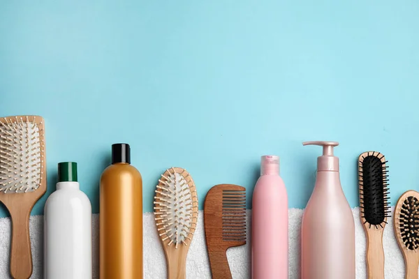 Płaska kompozycja z produktami kosmetycznymi do włosów i narzędziami na niebieskim tle. Miejsce na tekst — Zdjęcie stockowe