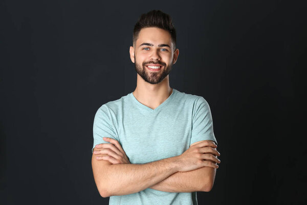 Portrait of handsome smiling man on black background