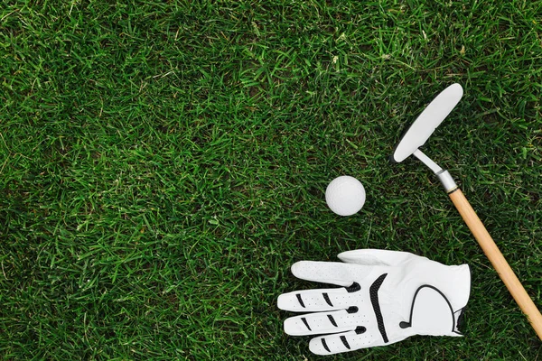 緑の草の上のゴルフクラブ、ボールと手袋、平らな横。テキスト用のスペース — ストック写真