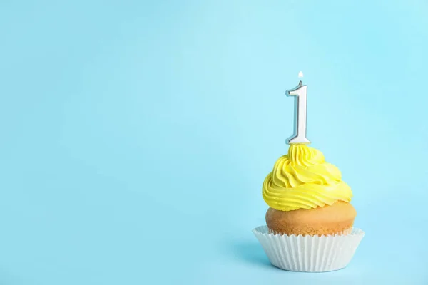 Cupcake d'anniversaire avec bougie numéro un sur fond bleu, espace pour le texte — Photo