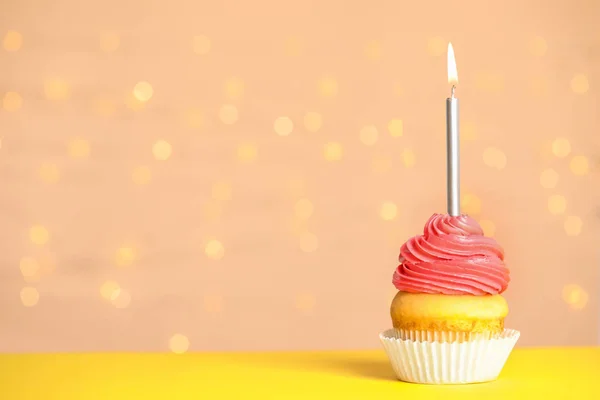Cupcake d'anniversaire avec bougie sur la table contre les lumières festives, espace pour le texte — Photo
