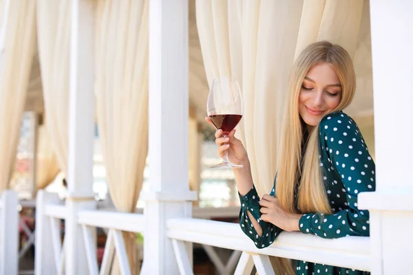 Красивая женщина с бокалом вина на террасе ресторана — стоковое фото