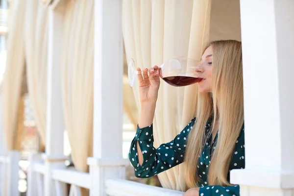 Красивая женщина пьет вино на террасе ресторана — стоковое фото