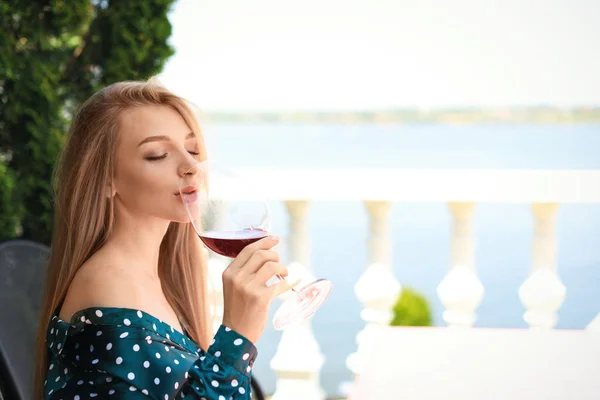 Красивая женщина пьет вино на террасе ресторана — стоковое фото