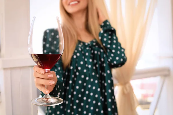 Молодая женщина держит бокал вина в открытом ресторане, крупным планом с местом для текста — стоковое фото