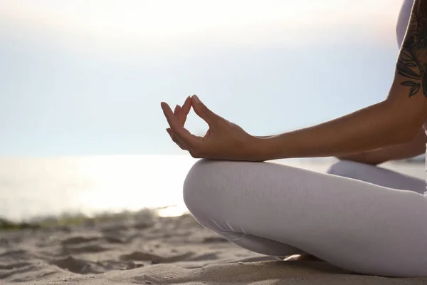 Wanita muda berlatih meditasi zen di pantai, closeup. Ruang untuk teks — Stok Foto