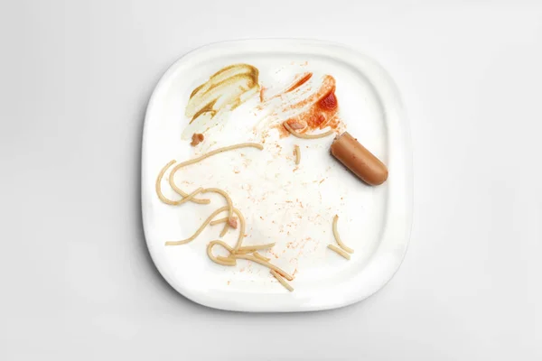 Placa sucia con sobras de comida sobre fondo blanco, vista superior — Foto de Stock