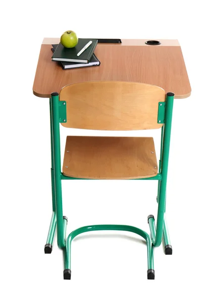 Деревянный школьный стол с канцелярскими принадлежностями и яблоком на белом фоне — стоковое фото