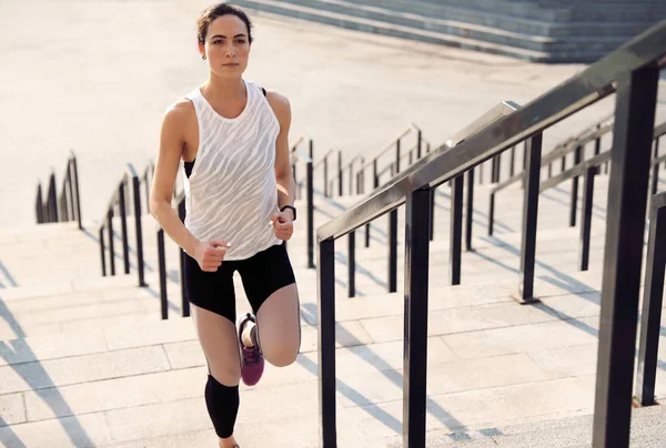 Mujer joven y deportiva corriendo arriba en un día soleado —  Fotos de Stock
