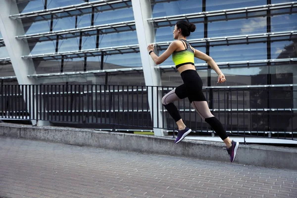 Bela jovem desportiva correndo na rua — Fotografia de Stock