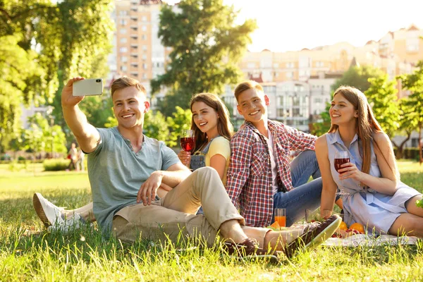 Jóvenes disfrutando de un picnic en el parque el día de verano — Foto de Stock