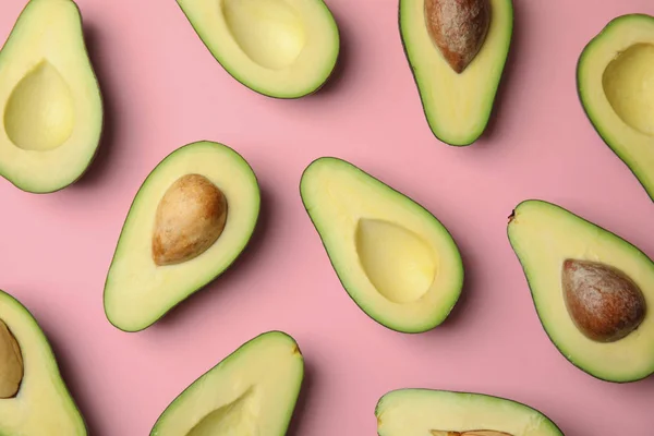 Gesneden verse rijpe avocado's op roze achtergrond, platte lay — Stockfoto