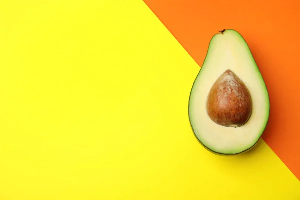 Geschnitten frische reife Avocado auf farbigem Hintergrund, Draufsicht mit Platz für Text — Stockfoto