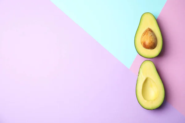 Snijd verse rijpe avocado op kleur achtergrond, platte lay met ruimte voor tekst — Stockfoto