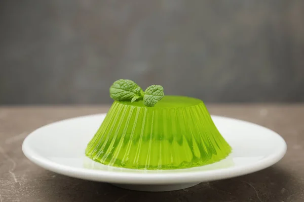 Placa con sabrosa gelatina de frutas y menta sobre mesa beige, espacio para texto — Foto de Stock