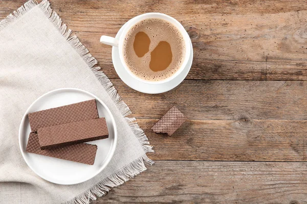 Placa de deliciosas obleas de chocolate con taza de café sobre fondo de madera marrón, vista superior. Espacio para texto —  Fotos de Stock