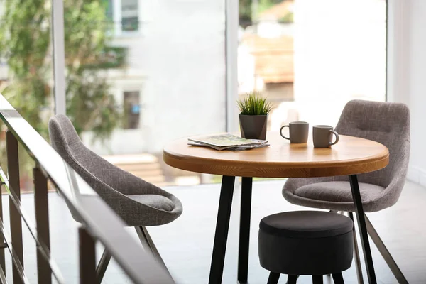 라운드 테이블과 편안한 의자가있는 세련된 객실 인테리어 — 스톡 사진