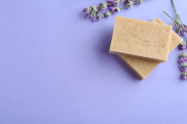 Barrette di sapone fatte a mano con fiori di lavanda su sfondo viola, posa piatta. Spazio per testo — Foto Stock