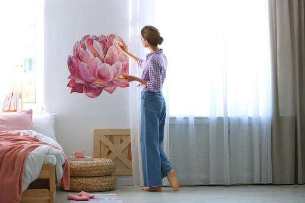 Młody projektant wnętrz malarstwo kwiat na ścianie w nowoczesnym pokoju — Zdjęcie stockowe