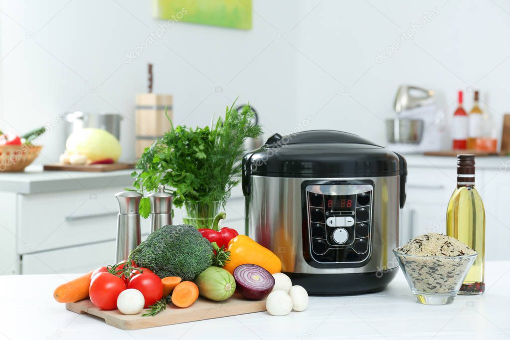 Modern multi cooker and products on kitchen table