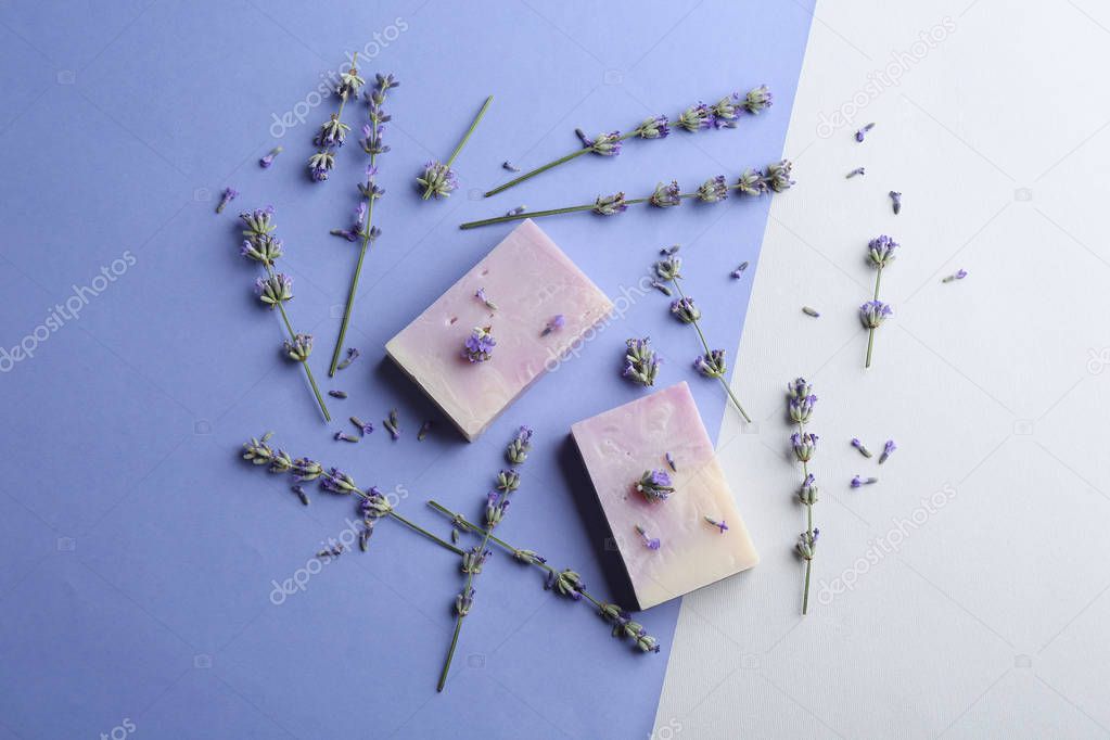 Hand made soap bars with lavender flowers on color background, flat lay