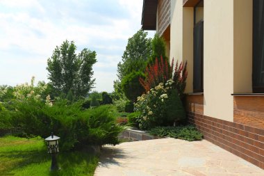 Güneşli bir günde modern ev ve güzel bahçe ile Peyzaj