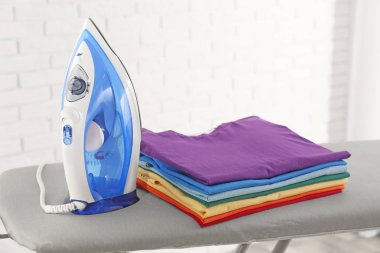 Modern elektrikli demir ve kapalı gemide katlanmış giysiler