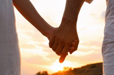 Romantik çift plajda el ele tutuşuyor, yakın çekim görünümü
