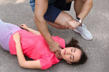 Genç adam sokakta baygın kadının nabzını kontrol