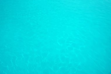 Arka plan olarak temiz mavi su ile yüzme havuzu yüzeyi