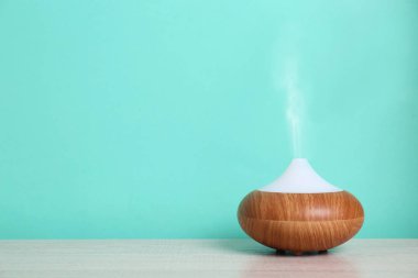 Uçucu yağlar turkuaz duvara yakın masada difüzör. Metin için alan