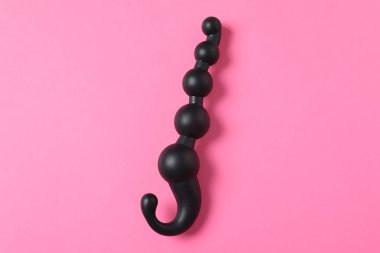 Pembe arka planda siyah anal top boncuklar, üst görünümü. Seks oyuncak