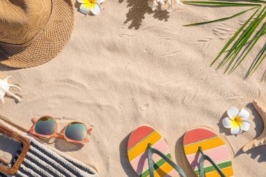 Kum üzerinde farklı plaj aksesuarları ile yapılan çerçeve, üst görünüm. Metin için alan