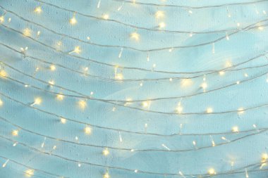 Açık mavi taş duvara asılı Noel ışıkları