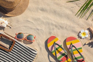 Kum üzerinde farklı plaj aksesuarları ile yapılan çerçeve, üst görünüm. Metin için alan