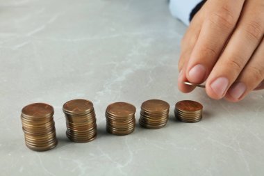 Gri taş masaüzerinde sikke istifleme Adam, closeup görünümü