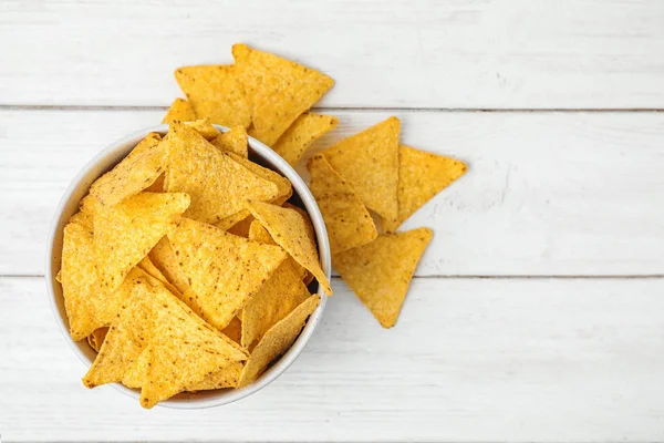 Kase ve beyaz ahşap masa üzerinde lezzetli Meksika nachos cips, düz yatıyordu. Metin için alan