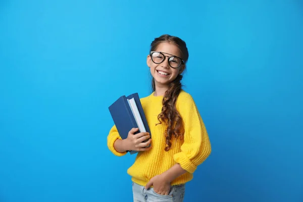 Menina bonito com óculos e livros sobre fundo azul. Conceito de leitura — Fotografia de Stock