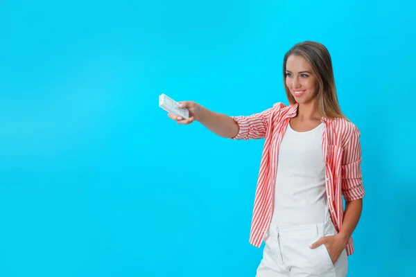 Ung kvinna med luftkonditionering fjärrkontroll på blå bakgrund. Utrymme för text — Stockfoto
