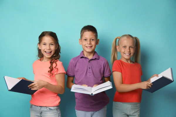 Portrét malých dětí četby knih na tyrkysové pozadí — Stock fotografie