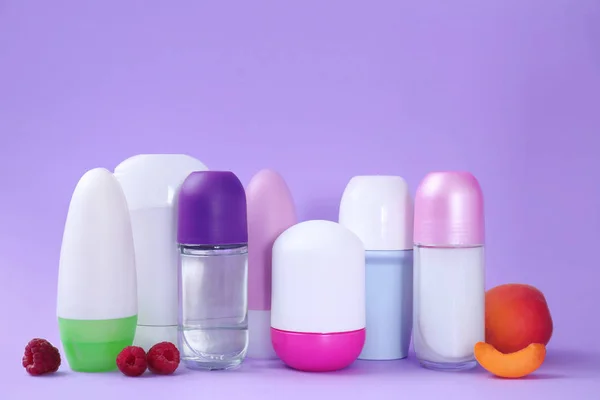 Composición con diferentes desodorantes femeninos sobre fondo púrpura, espacio para texto — Foto de Stock