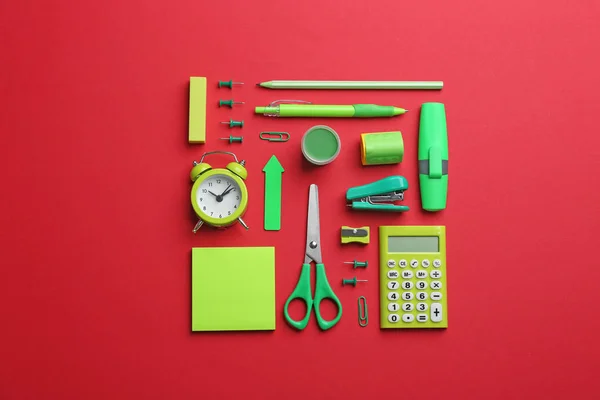 Zöld iskolai írószerek piros háttér, lapos feküdt — Stock Fotó